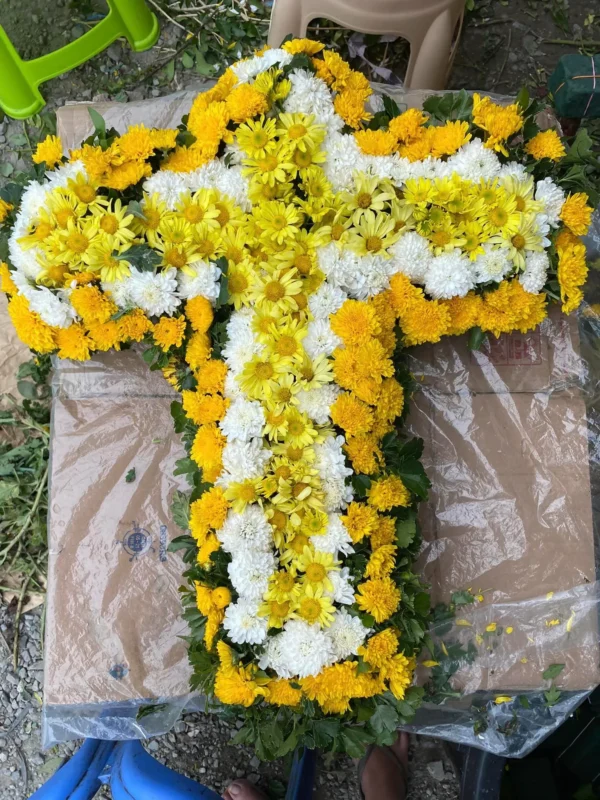 yellow and white daisies formed a cross funeral arrangement