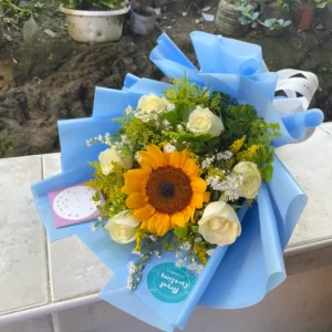 A bouquet of White Roses with a Sunflower in the middle.