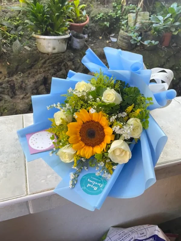 A bouquet of White Roses with a Sunflower in the middle.